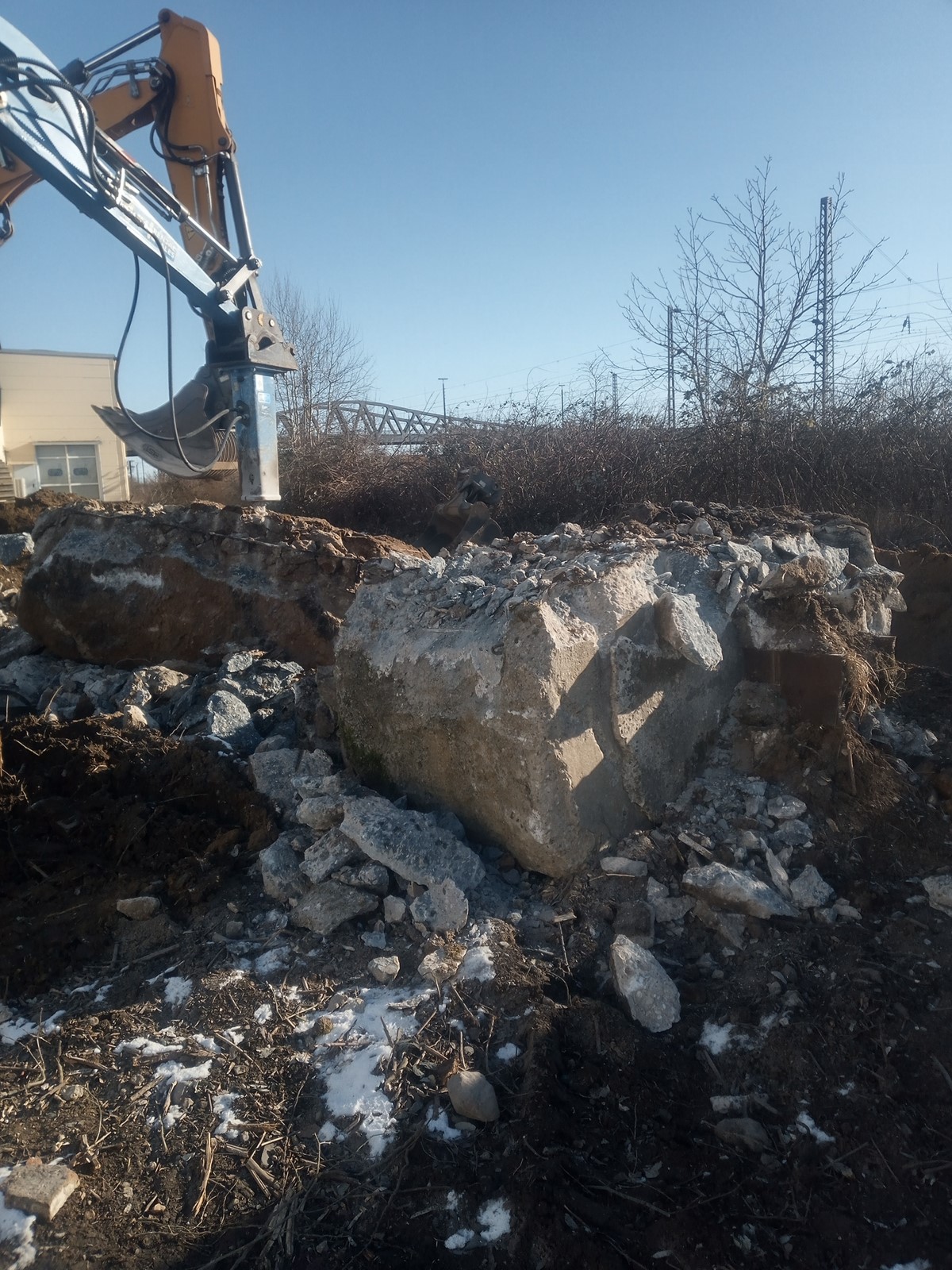 Abbruch1 Eine Baggerschaufel und ein Granitblock