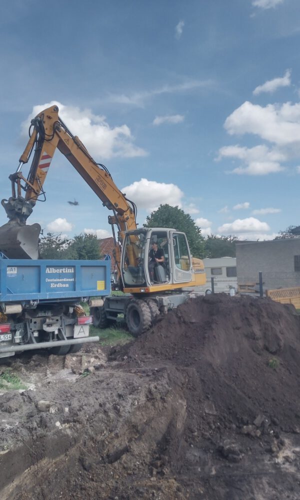 Ein Bagger belädt einen LKW mit Erde