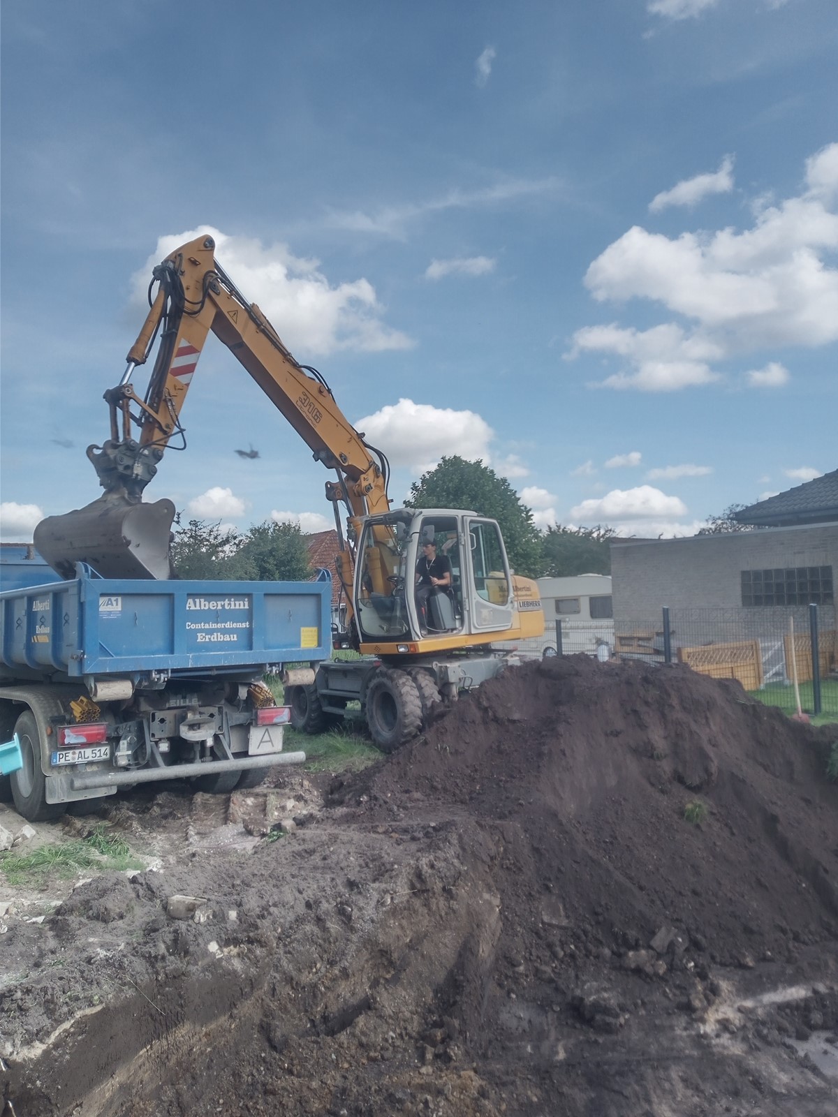 bagger-erdarbeiten3 Ein Bagger belädt einen LKW mit Erde