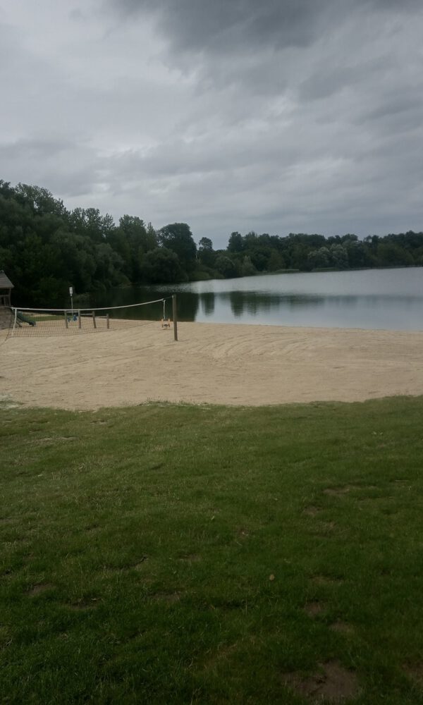 Ein Sandstrand vor einem See