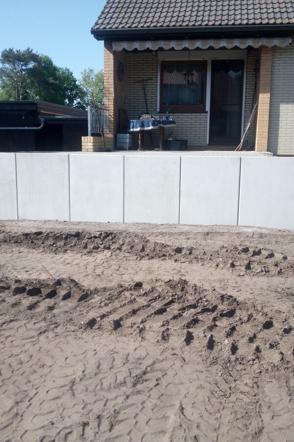 Ein Haus mit einer Terrasse. die mit hohen Borden eingefasst wurde